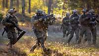 Bewaffnete Soldaten greifen in Formation an.