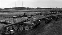 Schwarz-Weiß-Aufnahme: Mehrere Panzer stehen nebeneinander im Gelände