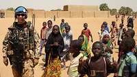Ein Objektschuetzer in Gao, Mali umgeben von Kindern.