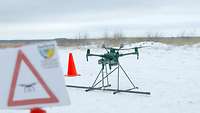 Drohnenfluggerät steht auf schneebedecktem Boden