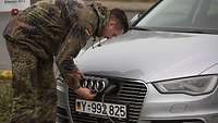 Ein Soldat lädt ein Elektroauto