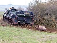 Pflegepanzer Dachs Ein Bundeswehrpanzer Dachs zieht eine rund vier Tonnen schwere Schleppe um Baumwuchs auf dem Gelände niederzuhalten.