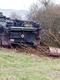 Ein Bundeswehrpanzer Dachs zieht eine rund vier Tonnen schwere Schleppe um Baumwuchs auf dem Gelände niederzuhalten.