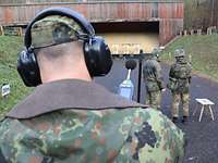 Lärm-Messung auf einer Standortschießanlage Ein Soldat mit Gehörschutz und einem Lärm-Messgerät steht auf einer Standortschießanlage hinter zwei Soldaten.