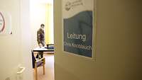 Eine halb geöffnete Tür zu einem Büro mit einem Hinweisschild auf den Leiter Chris Knoblauch.