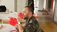Ein Soldat nimmt bei einer Typisierungsaktion ein Wattestäbchen in den Mund.