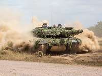 Ein Kampfpanzer Leopard während einer Übung Ein Kampfpanzer Leopard fährt durch das Gelände und wirbelt Staub auf