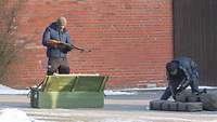 Die Soldaten stellen mit ihrer dunklen Bekleidung Schmuggler dar, die gerade Qualität und Funktionsfähigk der Waffen überprüfen.