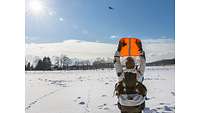 Einer der Soldaten hält eine orangene Warnweste in die Luft, um den Hubschrauberpiloten auf sich aufmerksam zu machen.