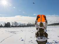 Einer der Soldaten hält eine orangene Warnweste in die Luft, um den Hubschrauberpiloten auf sich aufmerksam zu machen.