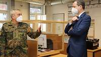 Ein Soldat erklärt dem Parlamentarischen Staatssekretär die Lage. 