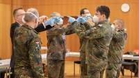 Führungskräfte beim Teambuilding im Hörsaal unter Corona-Bedingungen.