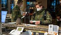 Ein Soldat steht am Empfang des Hotels und erhält seine Zimmerschlüssel.