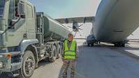 Eine Soldatin steht mit Warnweste neben einem Tankwagen am A400M