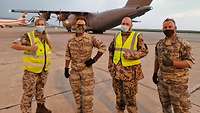 Deutsche und österreichische Soldatinnen und Soldaten stehen nebeneinander vor einem Flugzeug