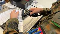 Ein Soldat hält einen Scanner in der Hand.