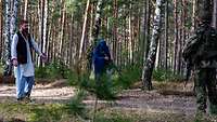 Soldaten stehen vor zwei, als bewaffnete Einheimische, verkleideten Trainern.