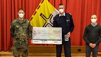 Oberstleutnant Heyde und Oberstabsfeldwebel Wolfgang Sunder bei der Scheckübergabe
