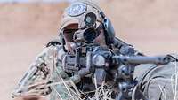Der MG-Schütze liegt in Stellung und hat seine Waffe im Anschlag