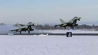 Zwei Eurofighter starten im verschneiten Ämari.