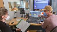 Zwei Männer sitzen im Tonstudio an einem riesigen Mischpult und nehmen die Stimme von Frau Major für den Content CAVE Heer auf.
