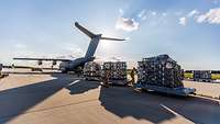 Ein A400M wird mit vollen Paletten an Hilfsgütern beladen.