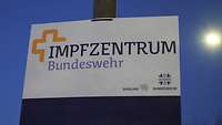 Ein Schild mit der Aufschrift „Impfzentrum Bundeswehr“ hängt an einem Laternenpfahl.