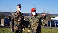 Ein Soldat erklärt einem anderen Soldaten etwas. 