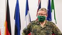 Dr Kowitz, with cloth face mask, Field-Uniform in Front of some Flags of the EU