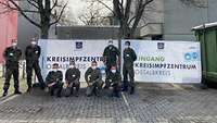 Acht Soldaten stehen vor dem Kreisimpfzentrum in Aalen zusammen für ein Gruppenfoto.