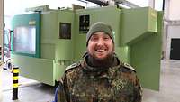 Hauptfeldwebel Benjamin Reschny steht in der Werkstatt der CNC-Fertigung.