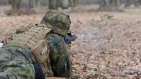 Ein Soldat liegt im Gelände und schießt mit einem G36 auf die Klappfallscheiben.