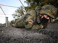 Ein Soldat kriecht über den Boden, um eine effektive Fortbewgung zu trainieren.