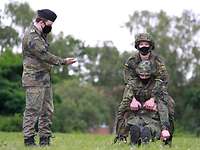 Ein Soldat schleift einen anderen Soldaten über den Boden zu Übungszwecken.