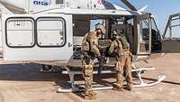 Soldaten laden einen großen Autoreifen in einen Hubschrauber