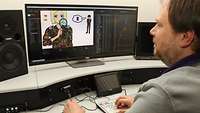 Ein Mann sitzt an einem Videoschnittarbeitsplatz mit Monitoren und spezieller, farbiger Tastatur