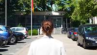 Frau läuft auf ein Gebäude zu