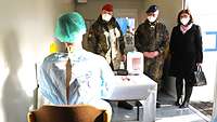 Ein Soldat erklärt den Generalen und der Stellvertretenden Landrätin seine Arbeitsschritte