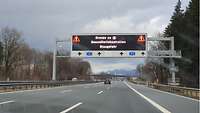 Hinweisschild auf der Autobahn A93. Dieses weist auf Gesundheistkontrollen und Staugefahr hin.