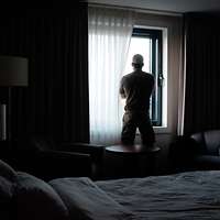 Ein Soldat steht in einem Raum vor einem Fenster und blickt nach draußen