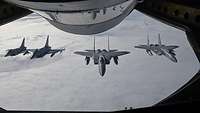 Deutsche Eurofighter und F-15-Jets der U.S. Air Force fliegen hinter einem KC-135-Tanker in Formation