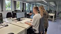 Vertreterin des Karrierecenters der Bundeswehr erklärt einem Bewerber den Test am Computer