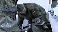 Zwei Soldaten stehen auf dem Heck des Schützenpanzers Marder und arbeiten an der Waffenwiege
