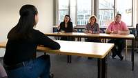 Eine Psychologin und zwei Beamte des zivilen Assessments führen ein Gespräch mit dem Bewerber 