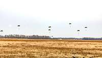 Fallschirmjäger bereiten sich in Manching auf die Landung vor Sieben Menschen an Fallschirmen landen auf einer Wiese