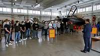 Junge Menschen und Flugzeuge in einer großen Halle