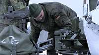 Zwei Soldaten stehen auf dem Heck des Schützenpanzers Marder und arbeiten an der Waffenwiege
