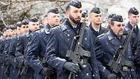 Der Ehrenzug marschiert in Reih und Glied mit ungeladenen Waffen.
