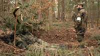 Zwei Soldaten liegen in einer gebuddelten Stellung und üben den Stellungskampf.