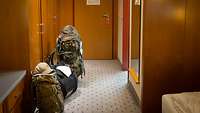 In einem Hotelflur stehen zur rechten und linken Seite Gepäckstücke vor Was den Zimmertüren